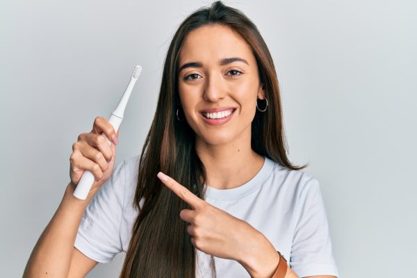 woman pointing to her toothbrush