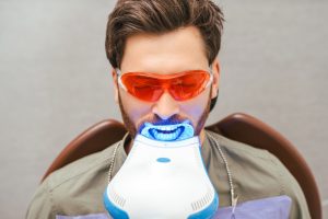 a man is undergoing professional teeth whitening treatment