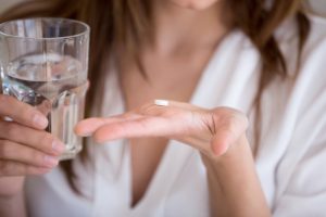 woman taking antibiotic orally